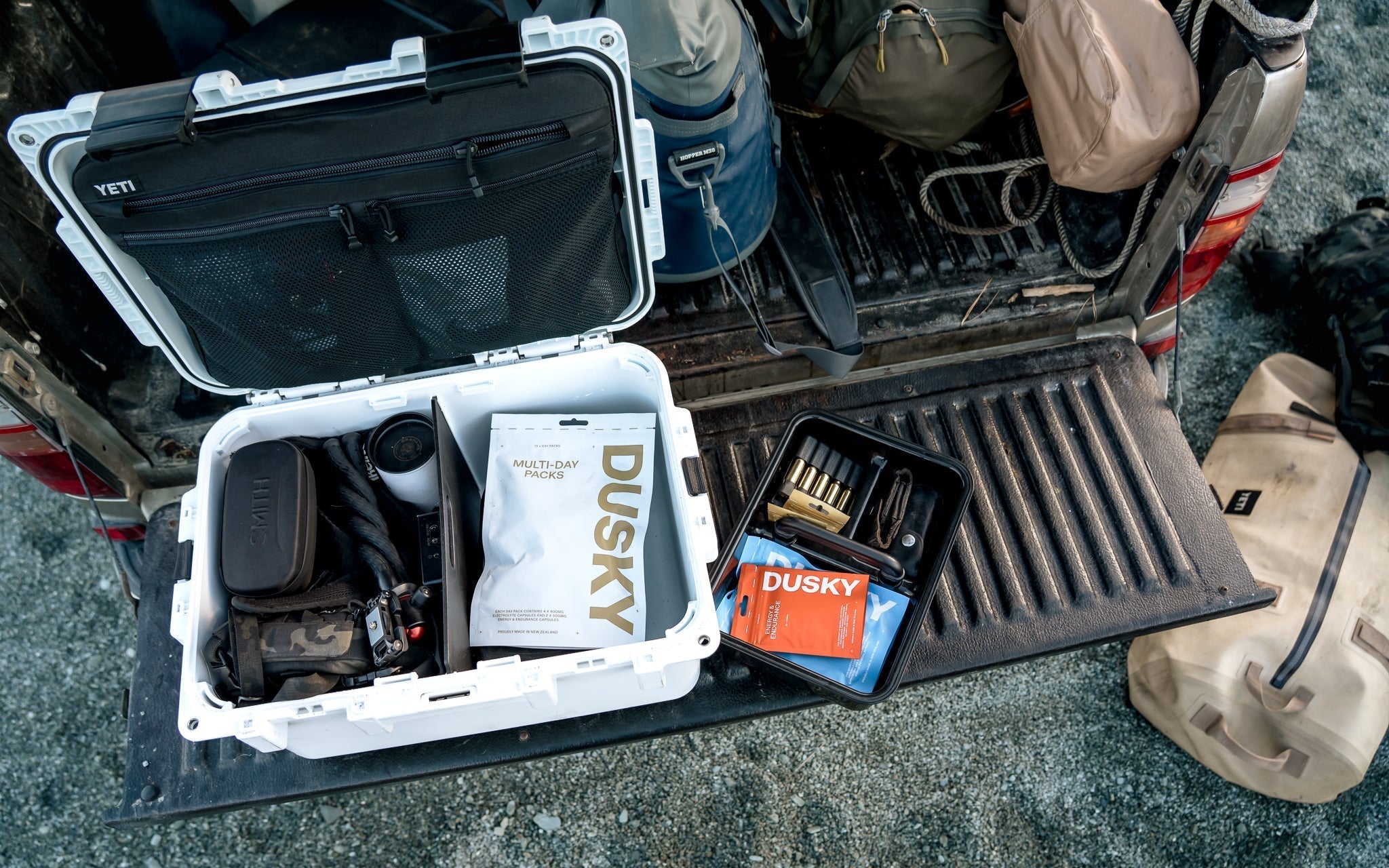 Dusky Day Pack and Multi-Day Pack packed alongside hunting gear and outdoor equipment for a backcountry adventure.
