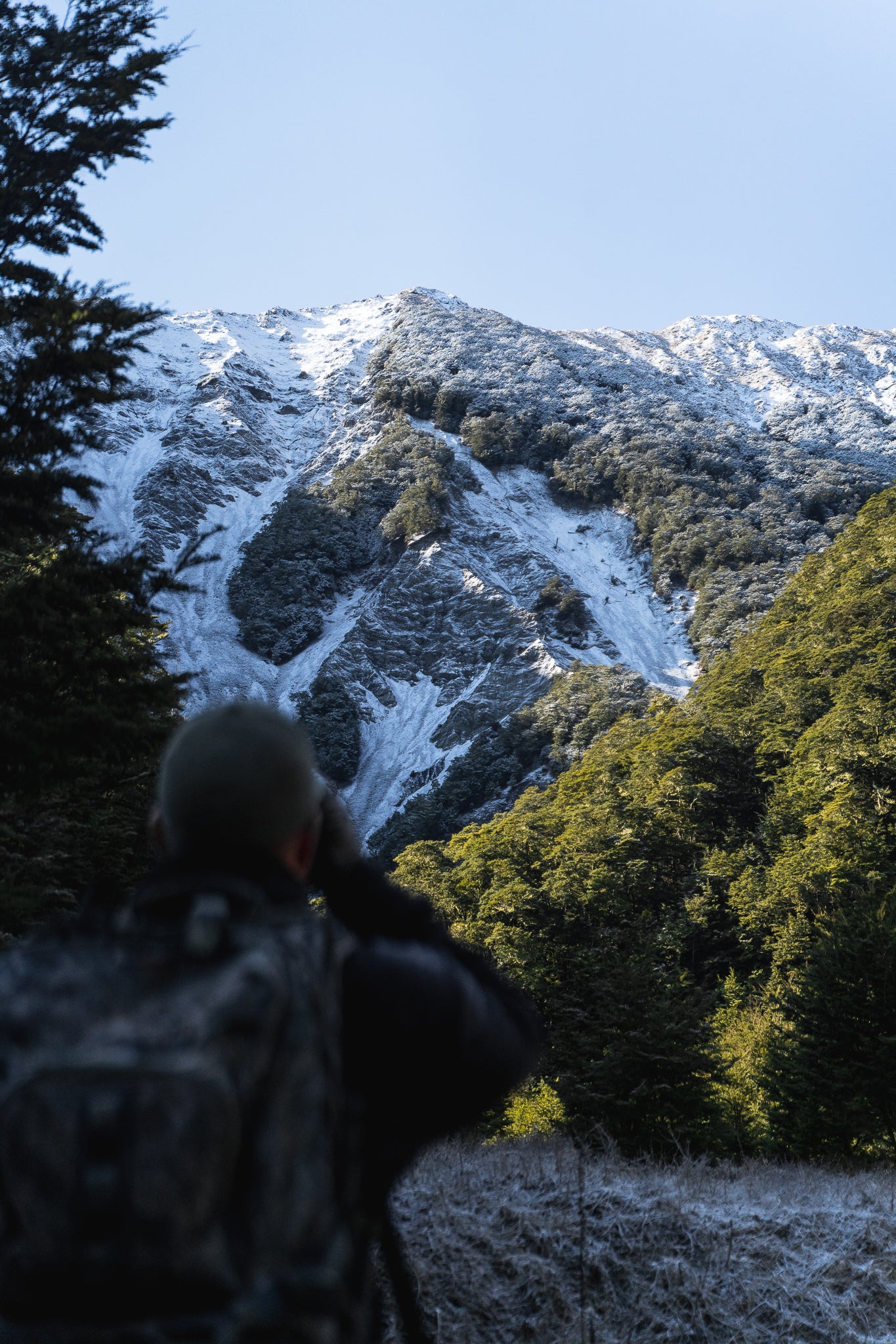 Hunter overlooking New Zealand alpine mountains during a day adventure with the Dusky Day Pack.