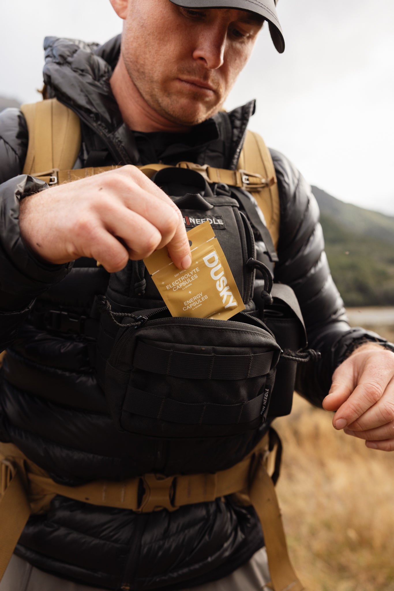 Hunter placing a Dusky Day pack into a frontpack binoharness before heading into the New Zealand backcountry. 